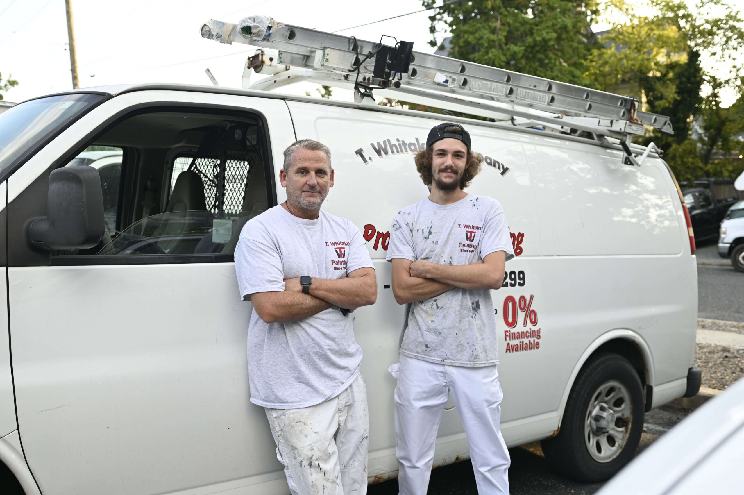 employees leaning against work truck